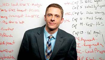 SPEA alumnus Lee Christenson in front of a white board covered with notes.