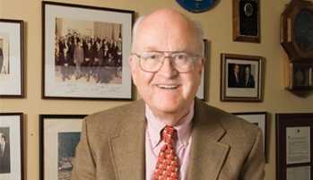 James Barnes in front of a wall of photos. 