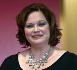 James Barnes in front of a wall of photos. 