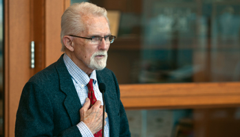 Alumnus Smalley puts his hand on his heart. 