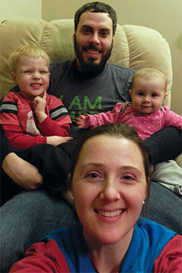 young family cuddles in a chair