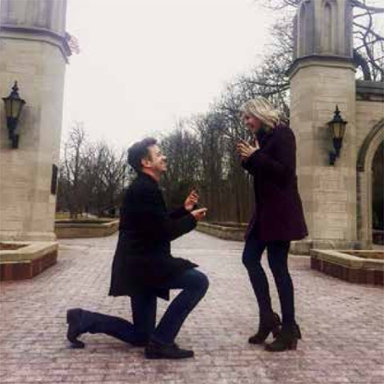 man proposes to woman in front of sample gates