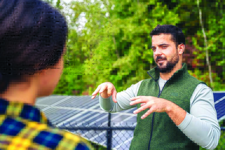 Students work in field with Indy skyline in back.